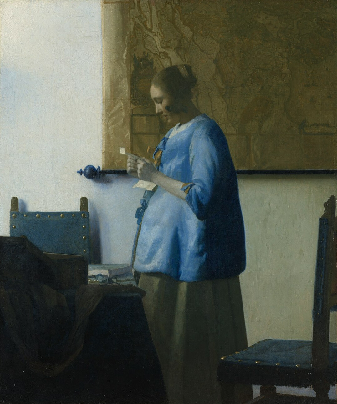 Female archivist in her thirties examining a historical document with white cotton gloves